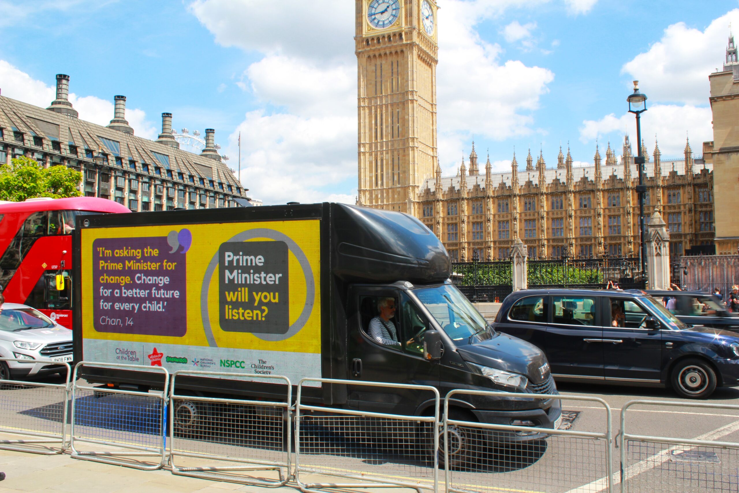 Black van outside House of Commons with a yellow screen with the Children At The Table Logo and text asking for change. 