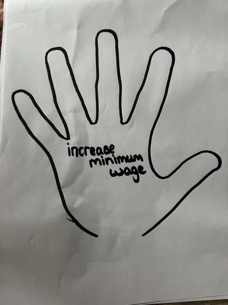 Handprint drawn by a young person, message inside the handprint reads 'Increase minimum wage'